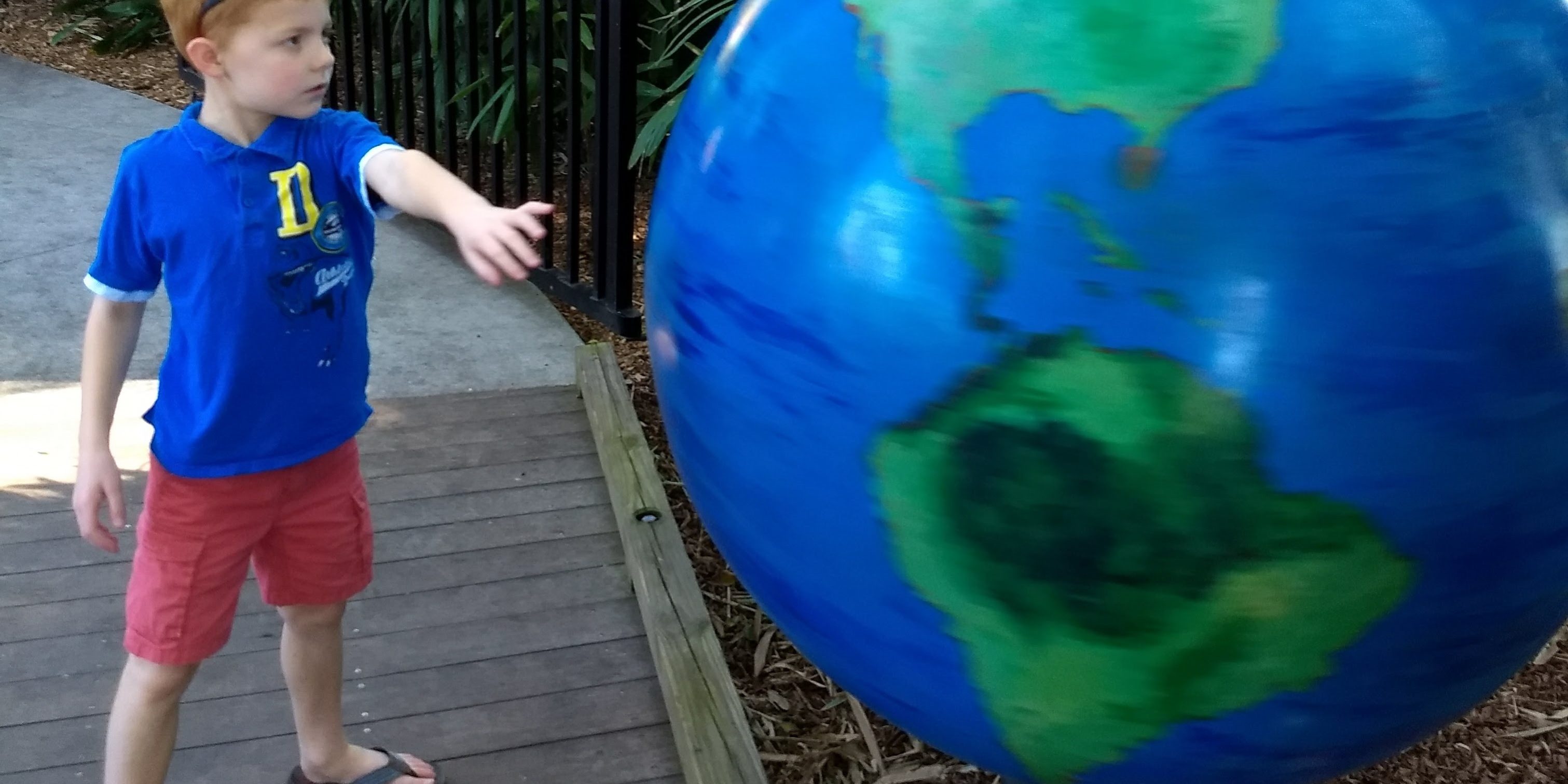 Boy spinning giant globe