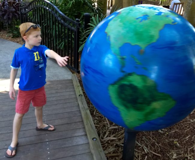 Boy spinning giant globe