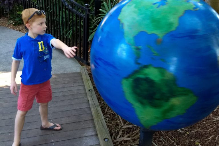 Boy spinning giant globe